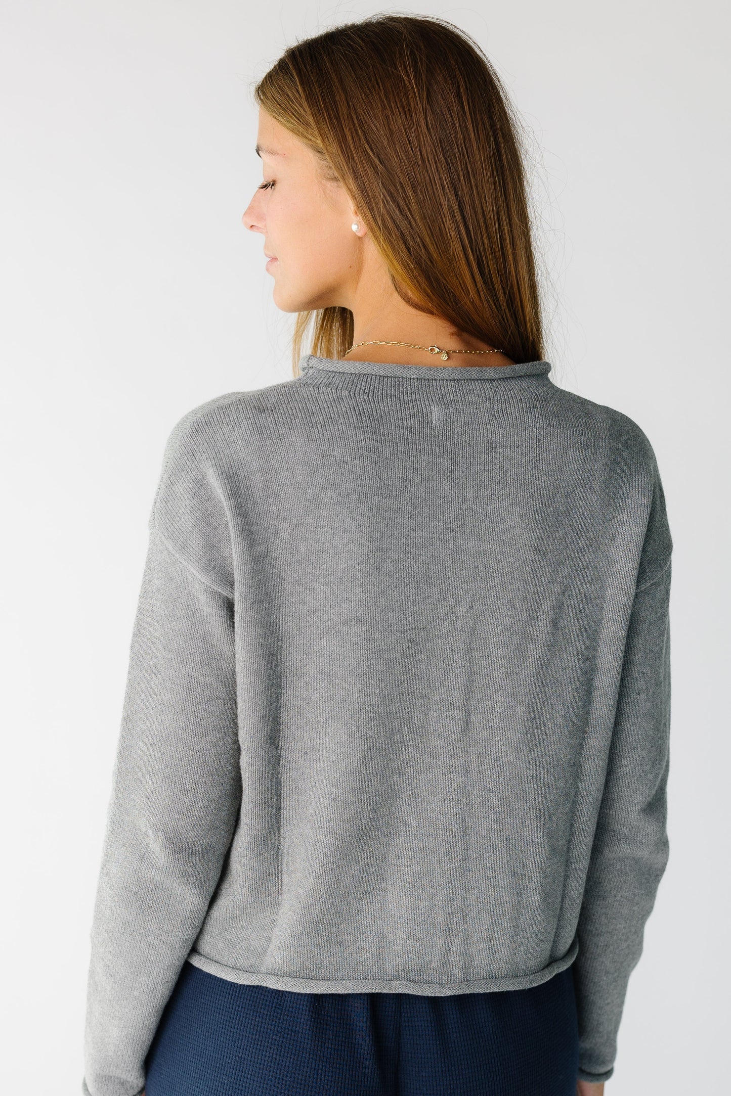 Back view of a woman wearing a grey long sleeve sweater