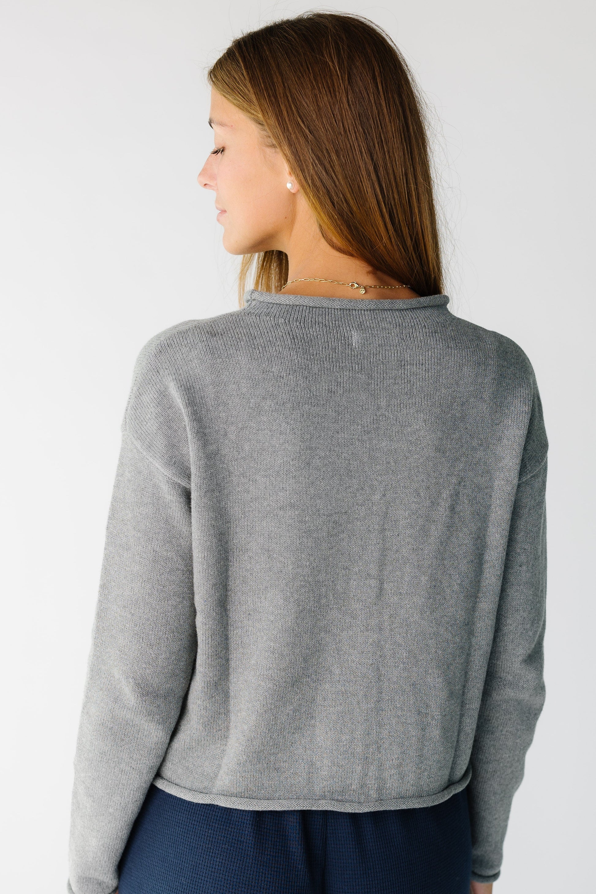 Back view of a woman wearing a grey long sleeve sweater
