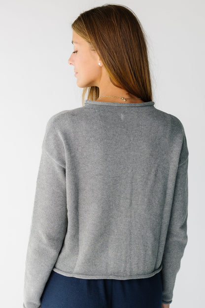 Back view of a woman wearing a grey long sleeve sweater