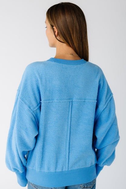 Back view of a woman wearing a blue loose fitting sweatshirt