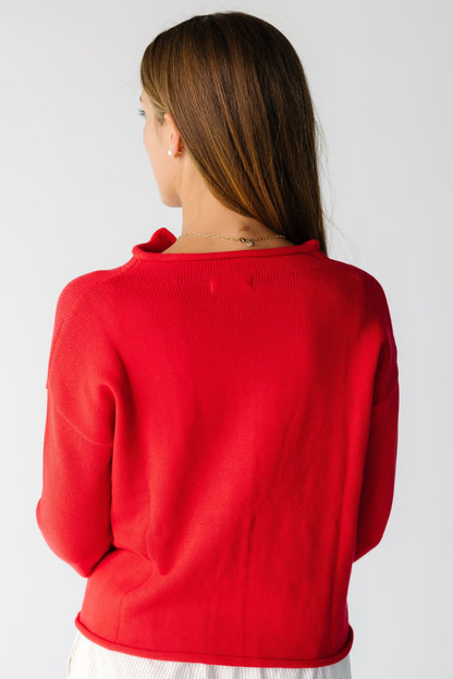 Back view of a woman wearing a red cardigan with rolled hems