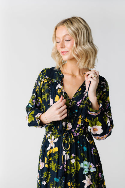 Close view of navy floral dress with V-neckline and long sleeves and drawstring waist