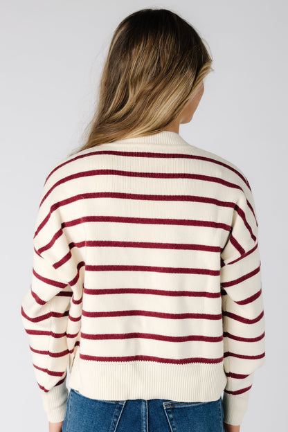 Back view of a woman wearing a burgundy and ivory stripe sweater
