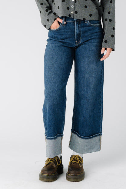 Woman wearing a modest pair of very wide jeans with mid rise and wide bottom cuffs