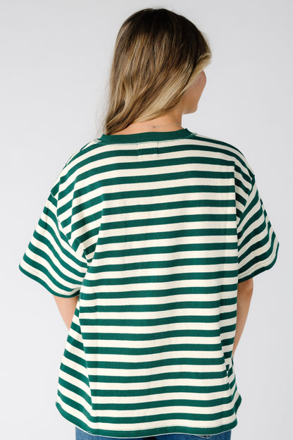Back view of a woman wearing a green stripe loose fitting tee with short sleeves