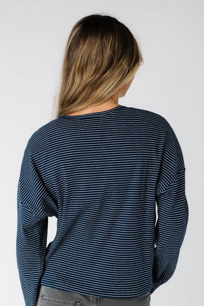 Back view of a woman wearing a navy pinstripe  cardigan with long sleeves