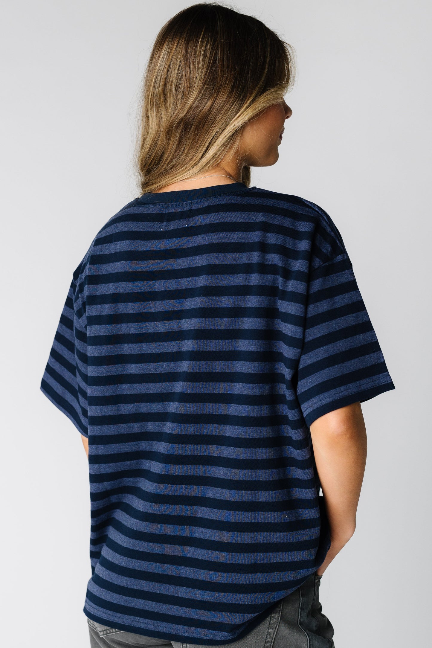 Back view of a woman wearing a navy stripe tee with short sleeves