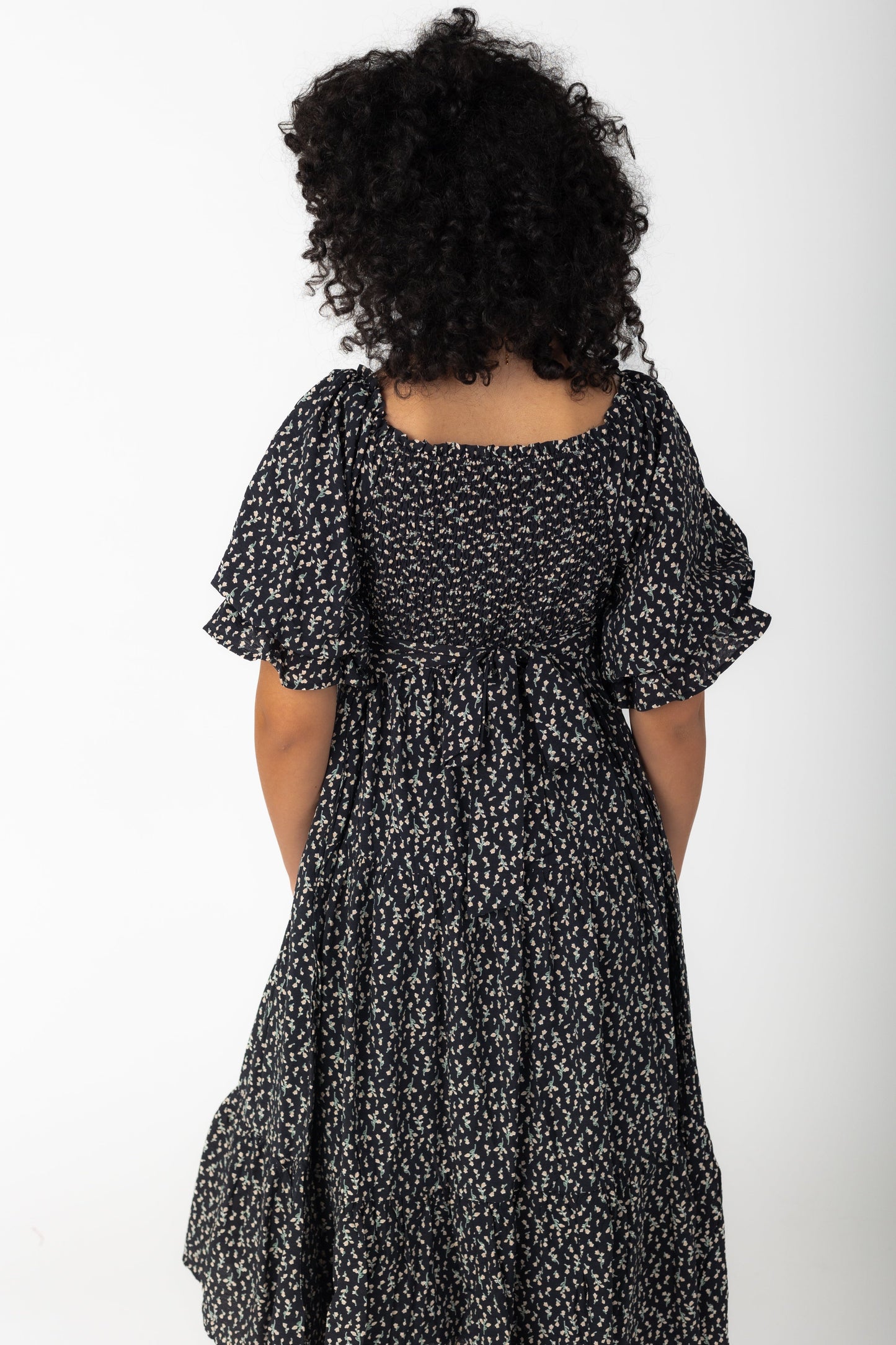 Back view of black print midi with square neckline and balloon sleeves