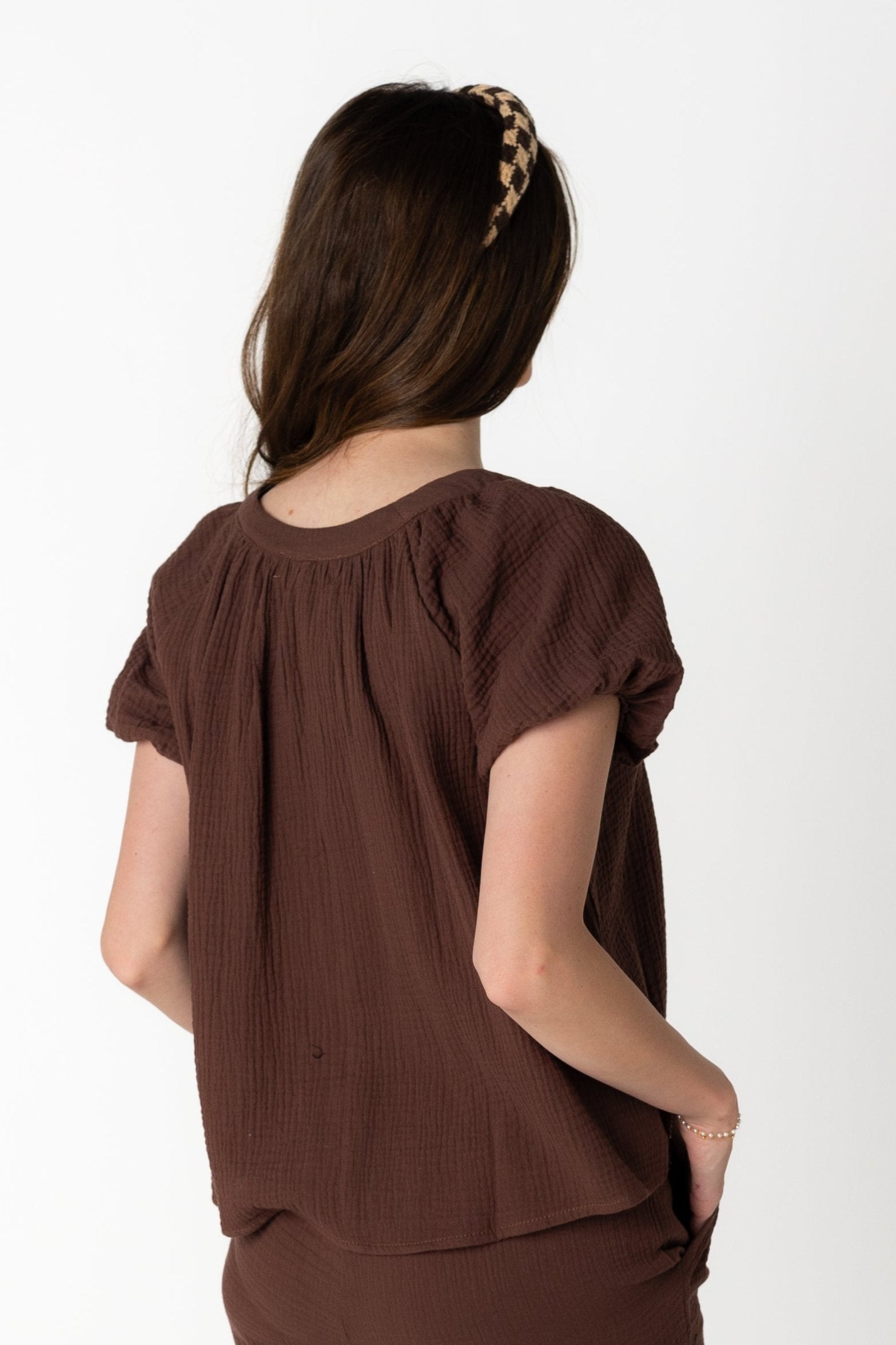 Back view of brown gauzy scoop neck top with short sleeves