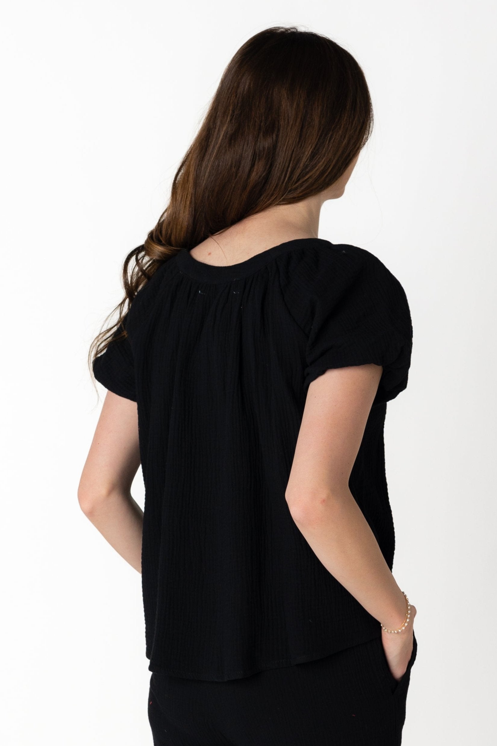 Back view of black scoop neck top with puff sleeves