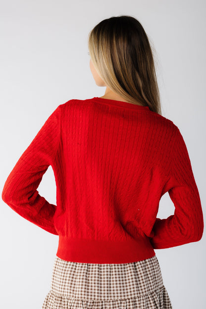 Back view of a woman wearing a long sleeve cardigan in red