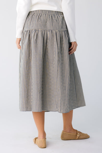 Back view of a woman wearing a navy gingham midi skirt