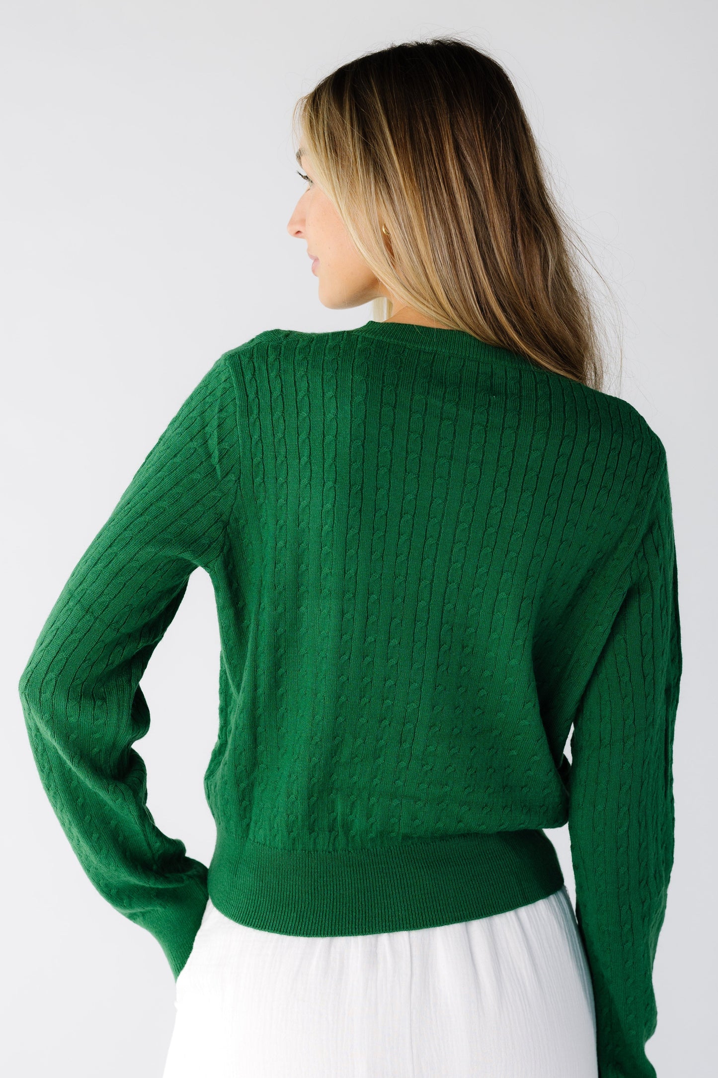 Back view of a woman wearing a green long sleeve cardigan
