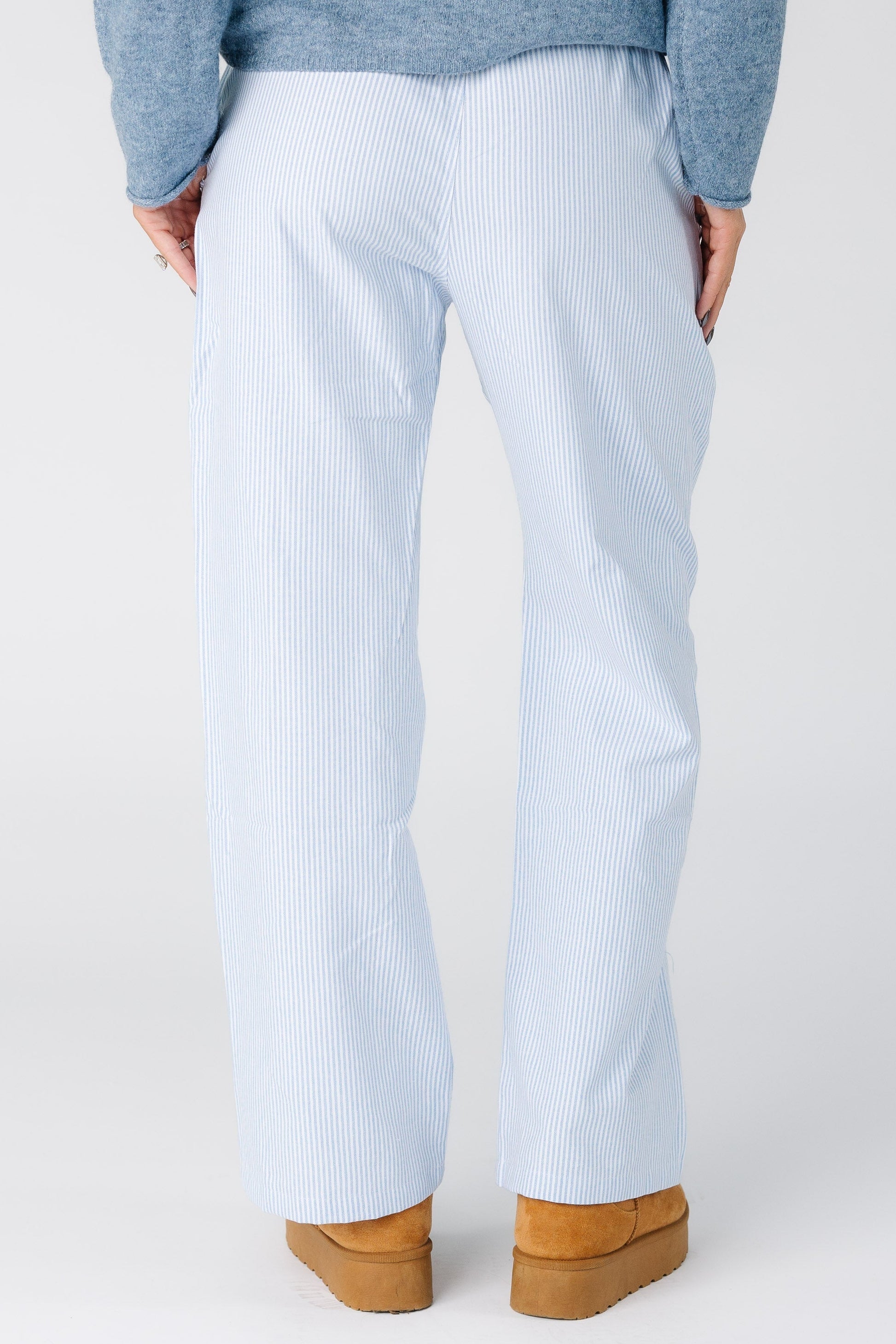 Back view of a woman wearing a blue and white stipe pant with wide cut legs