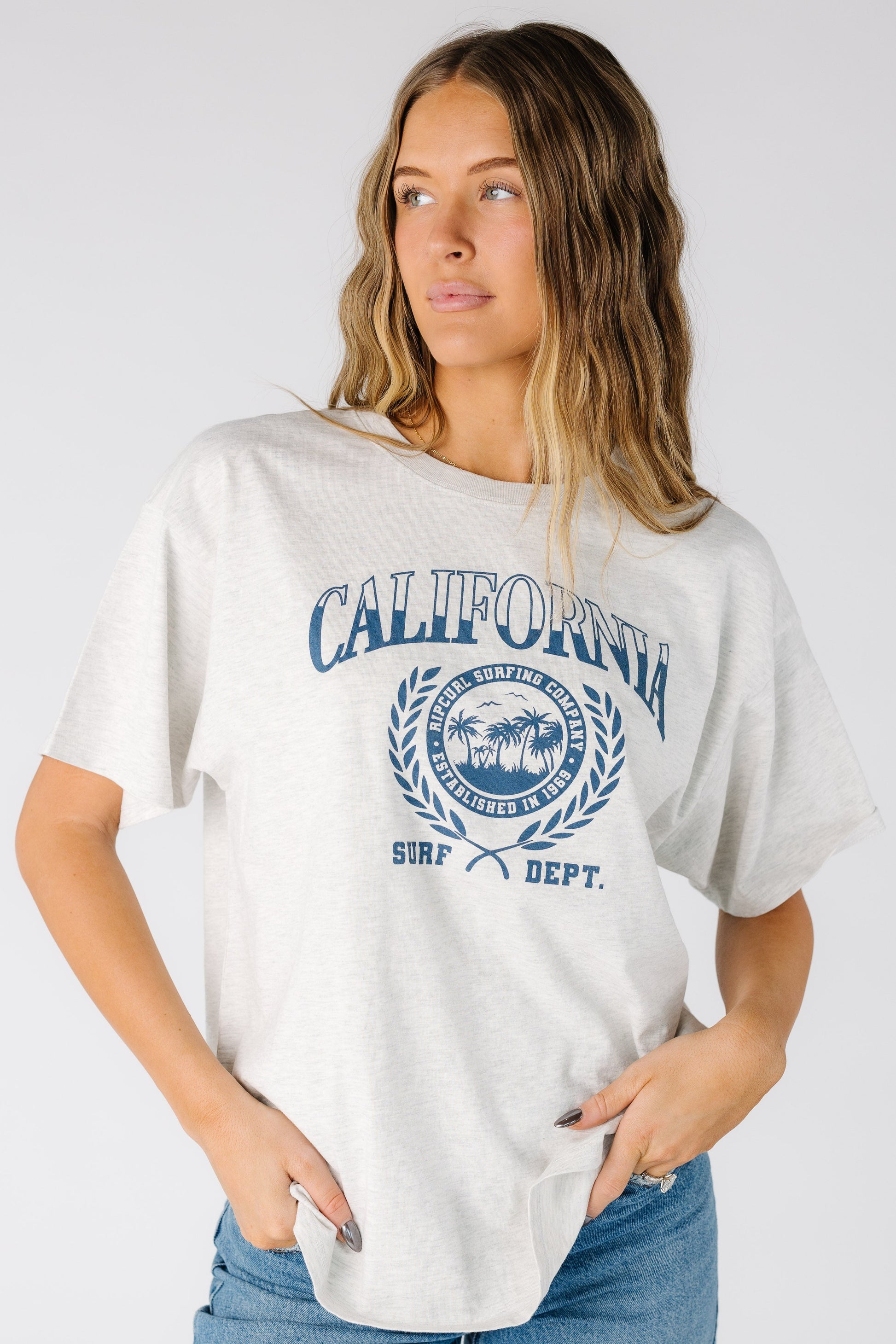 Woman wearing a light grey short sleeve tee with a large front graphic 0JZWTE