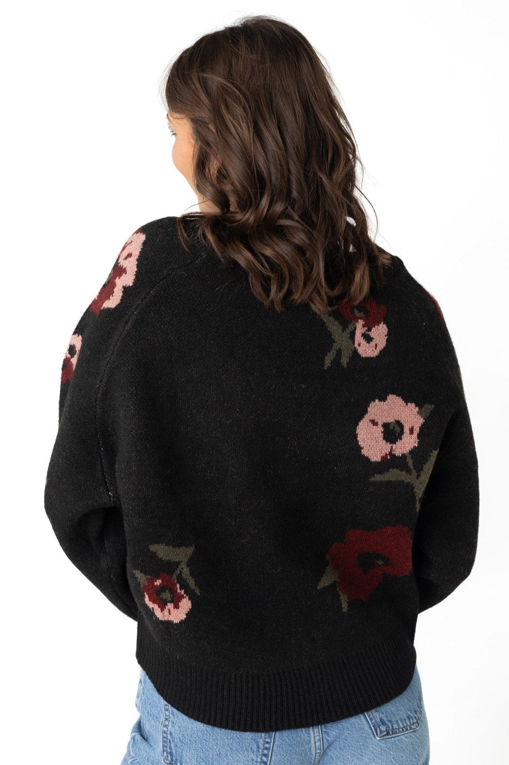 Back view of loose fitting  black floral sweater  with long raglan sleeves