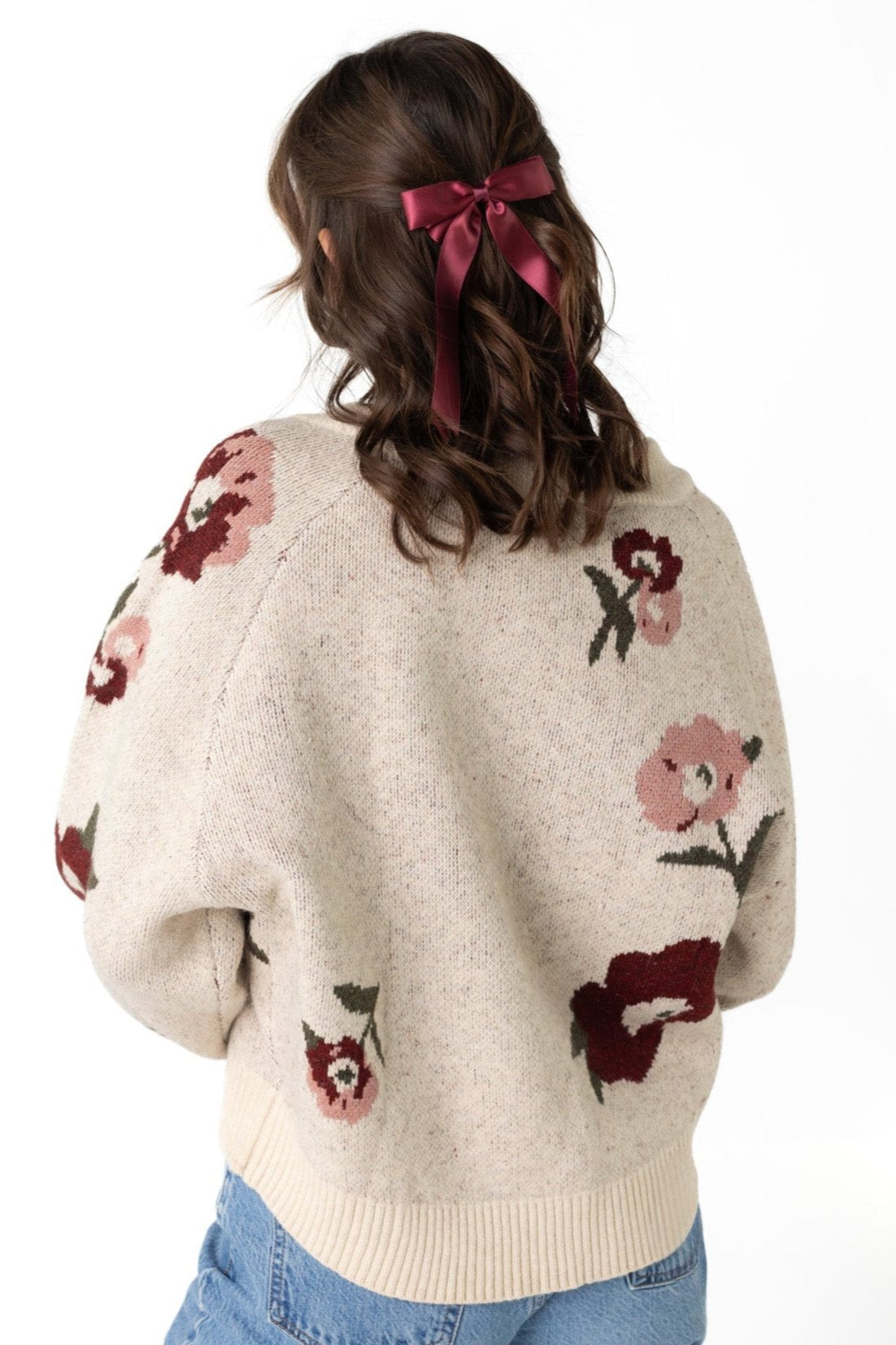 Back view of cream  loose fitting sweater  with floral pattern and long raglan sleeves