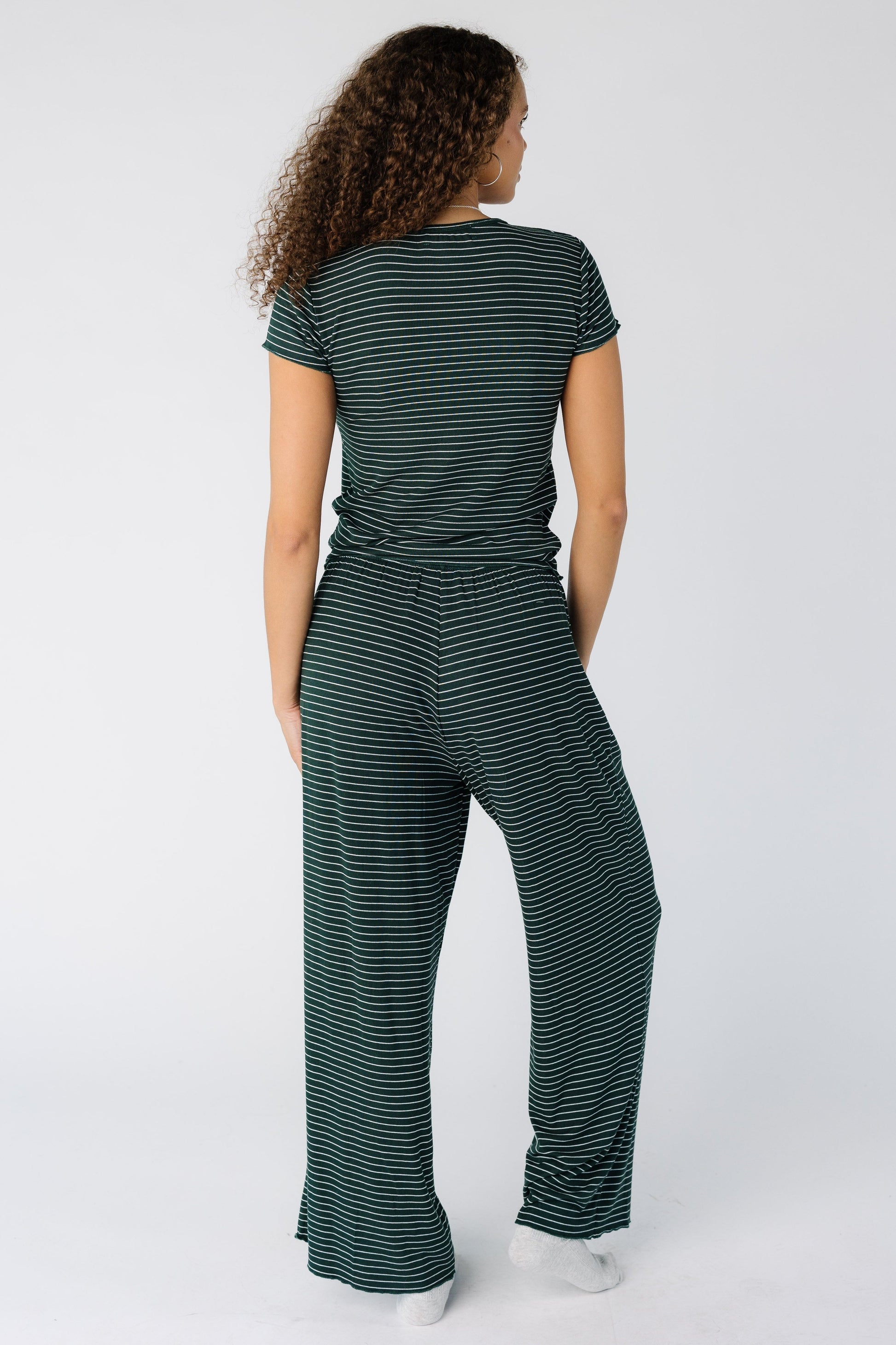 Back view of a woman wearing a green stripe pajama lounge set