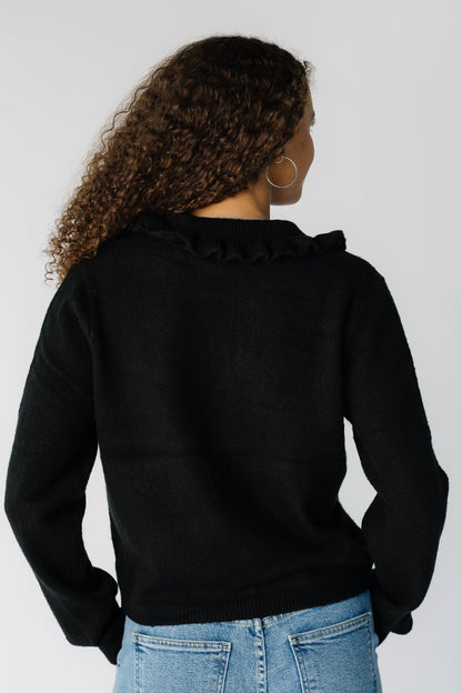 Back view of a woman wearing a black long sleeve cardigan