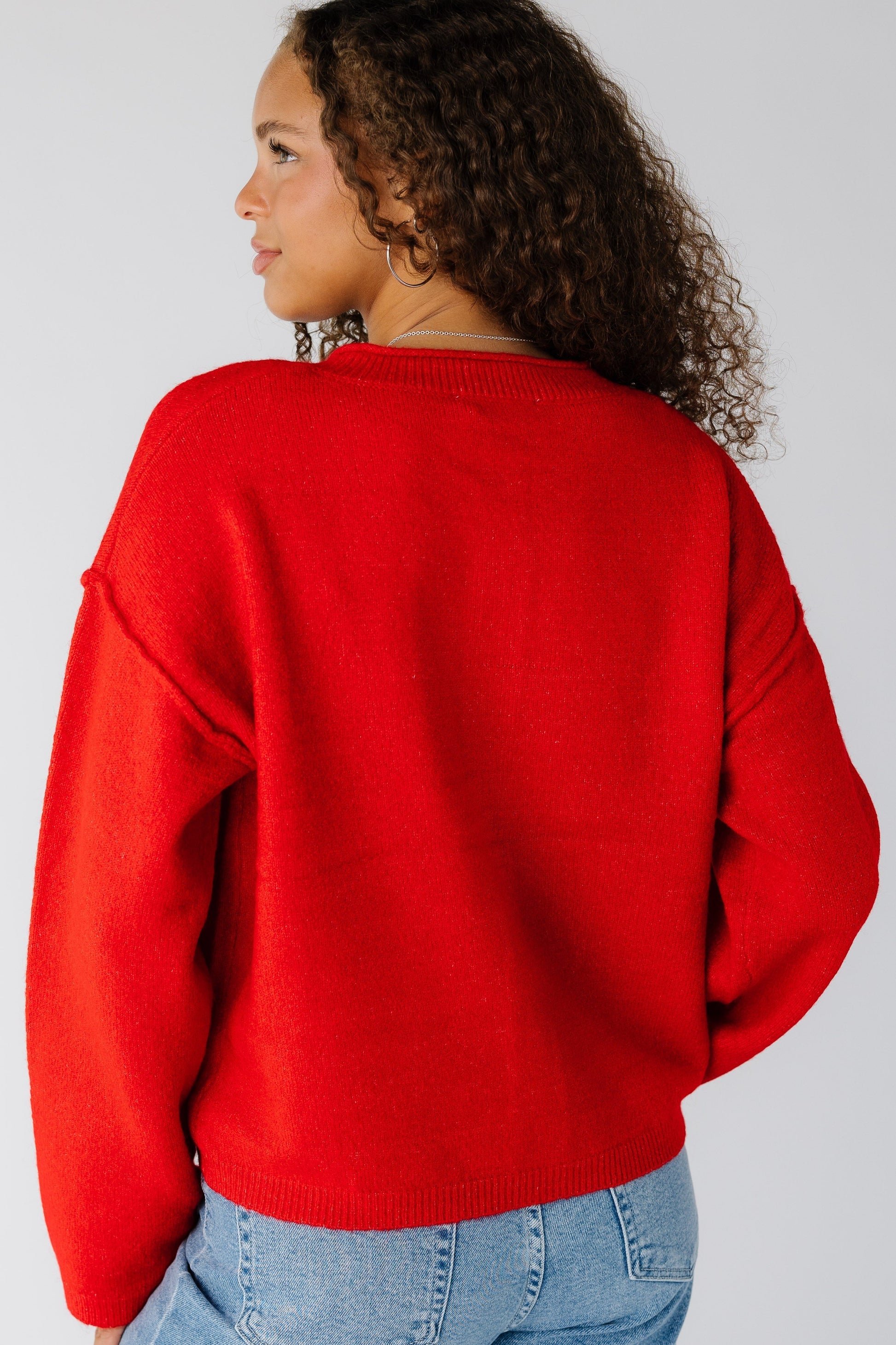 Back view of a woman wearing a red long sleeve cardigan