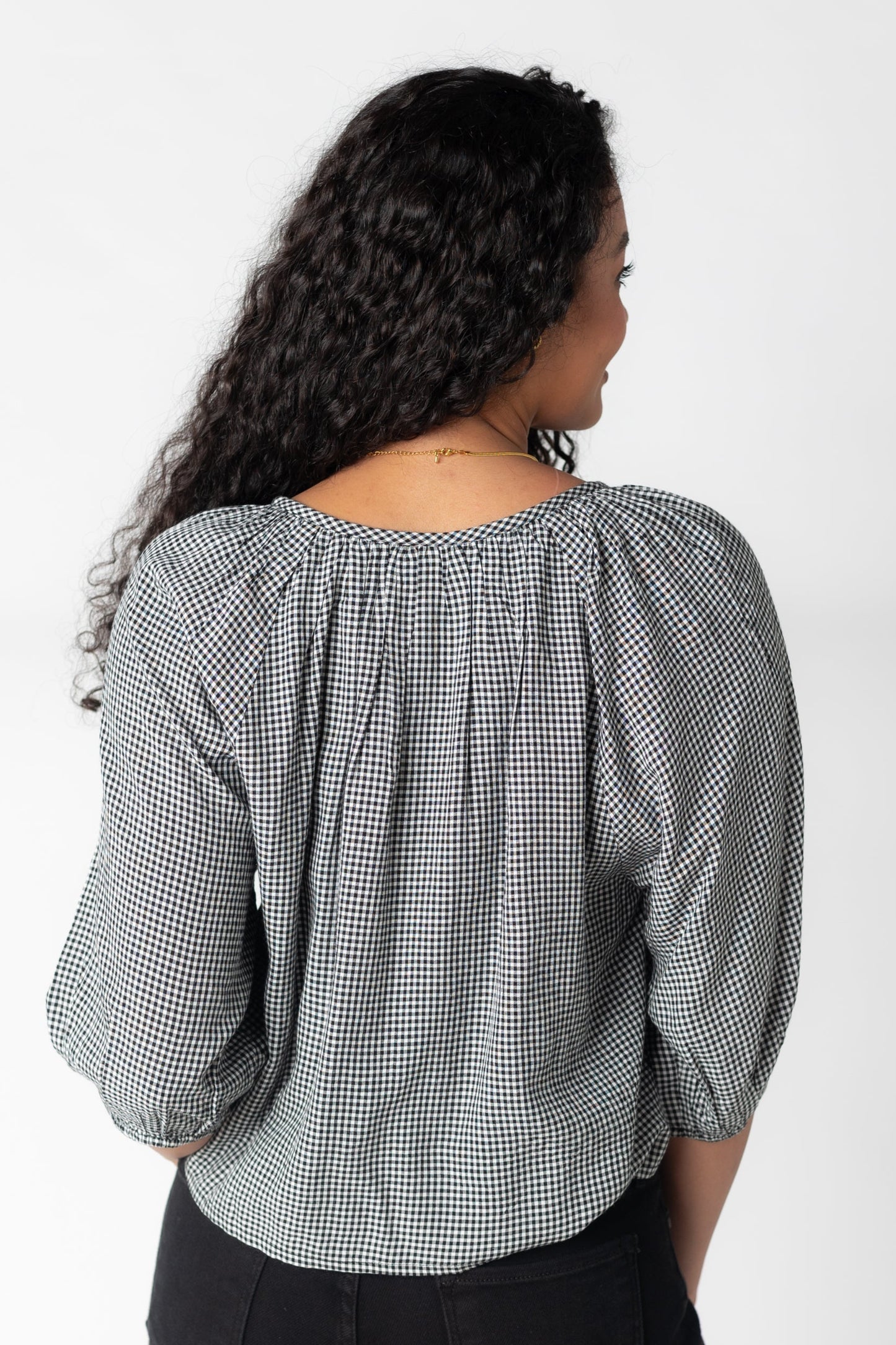 Back view of black and white gingham loose fitting top