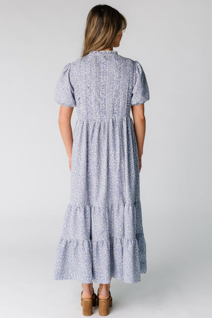 Back view of a woman wearing a ruched and pleated bodice and midi skirt.