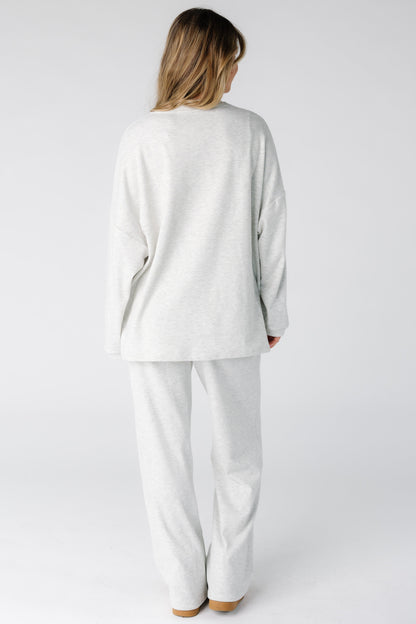 Back view of a woman wearing a 2 piece lounge set in light grey.