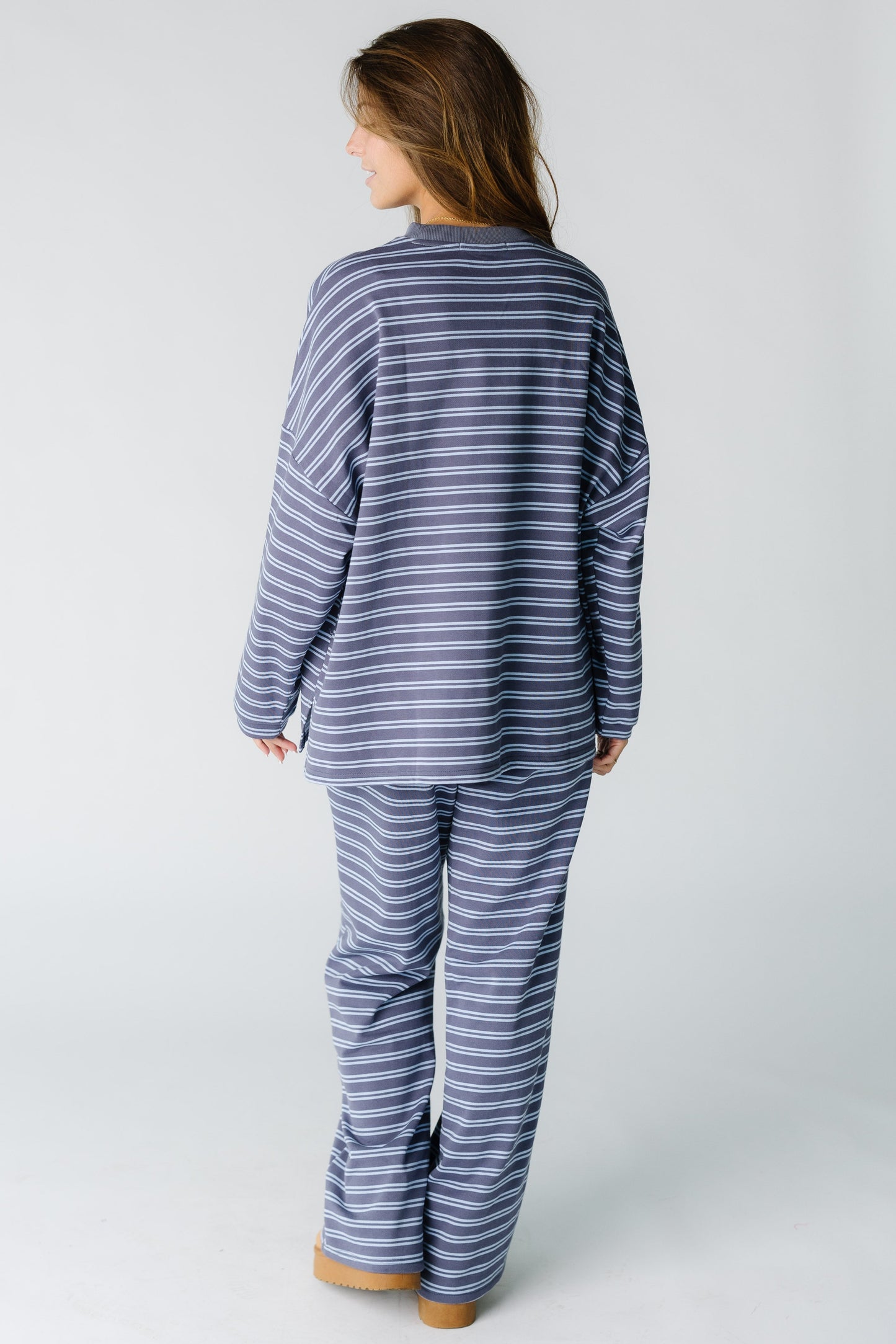 Back view of a woman wearing plum and blue stripe lounge set