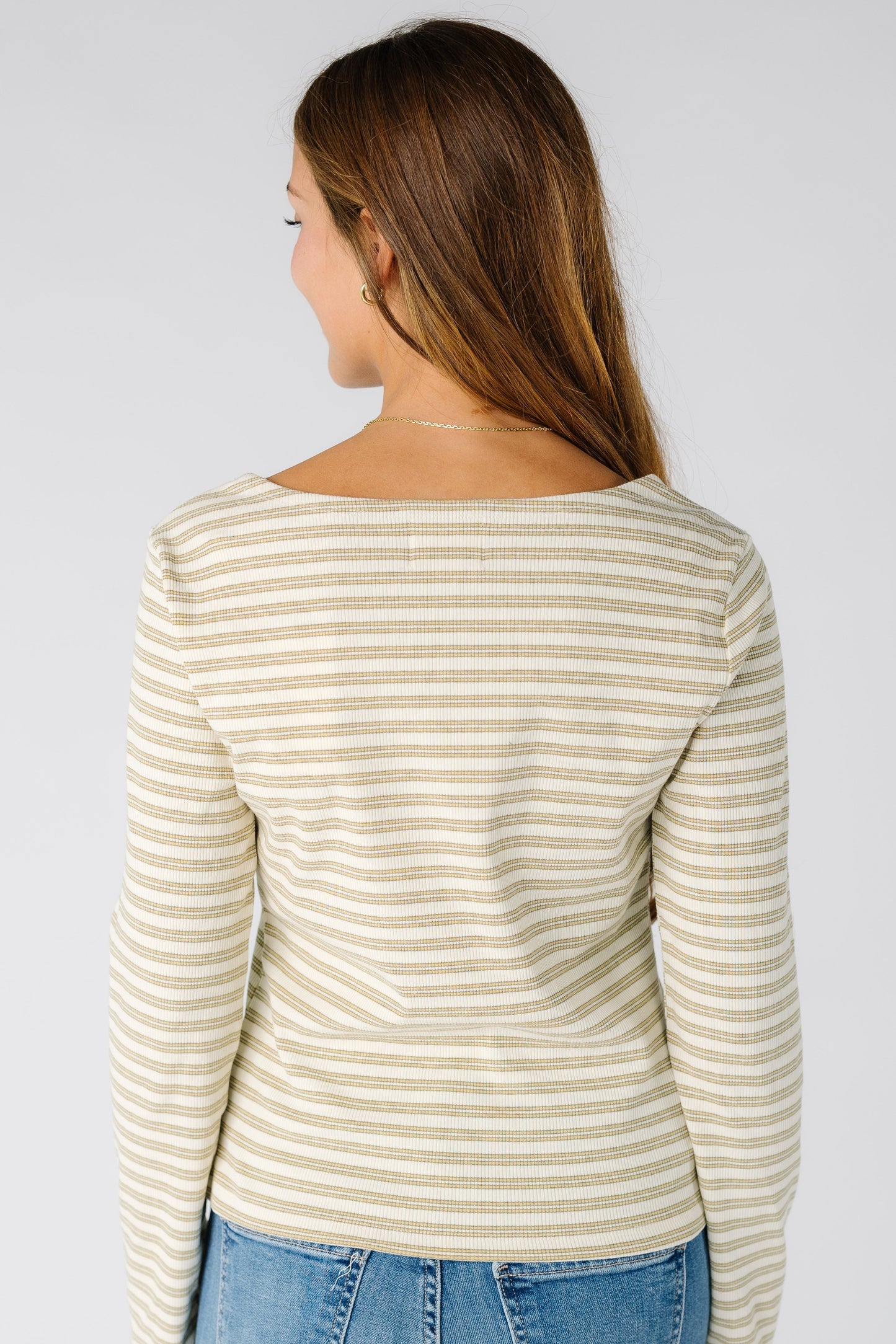 Back view of a woman wearing a yellow stripe top with long sleeves