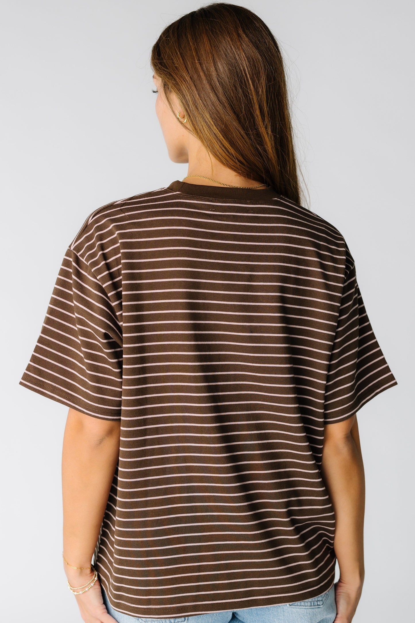 Back view of a woman wearing a brown stripe t-shirt with short sleeves