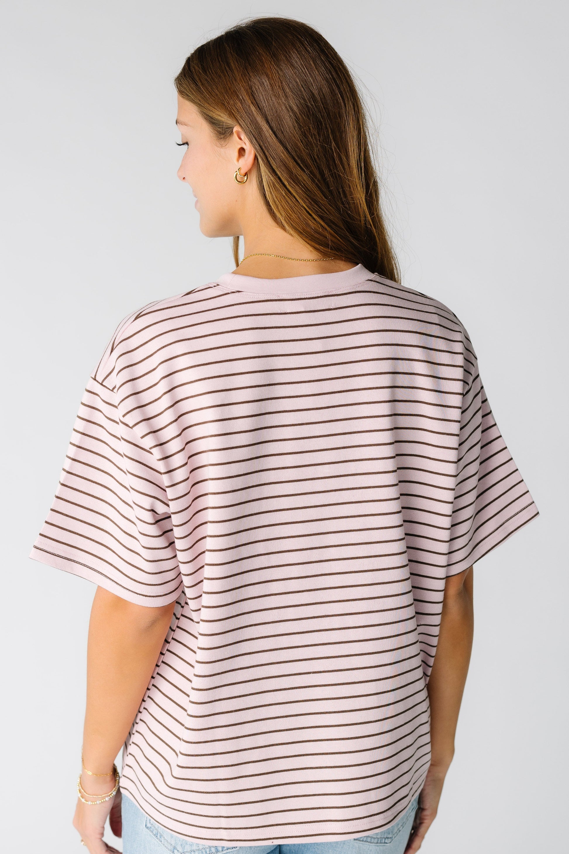 Back view of a woman wearing a pink stripe boxy tee with short sleeves