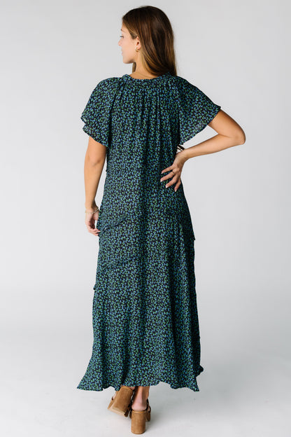 Back view of a woman wearing a blue and black floral  maxi dress