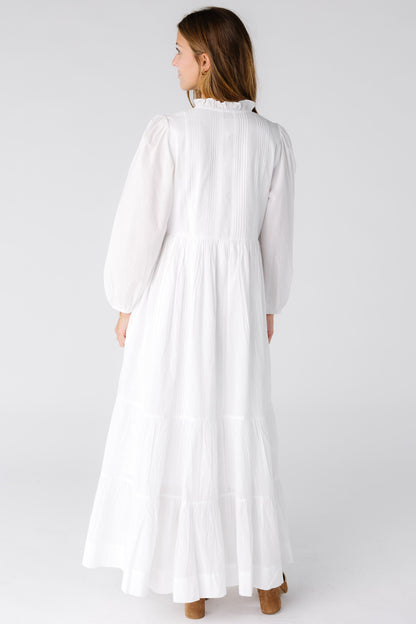 Back view of a woman wearing a white maxi dress with long sleeves