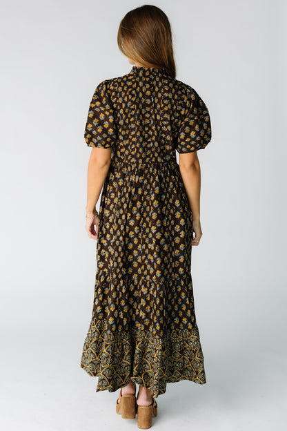 Back view of a woman wearing a brown floral midi-maxi dress with short sleeves