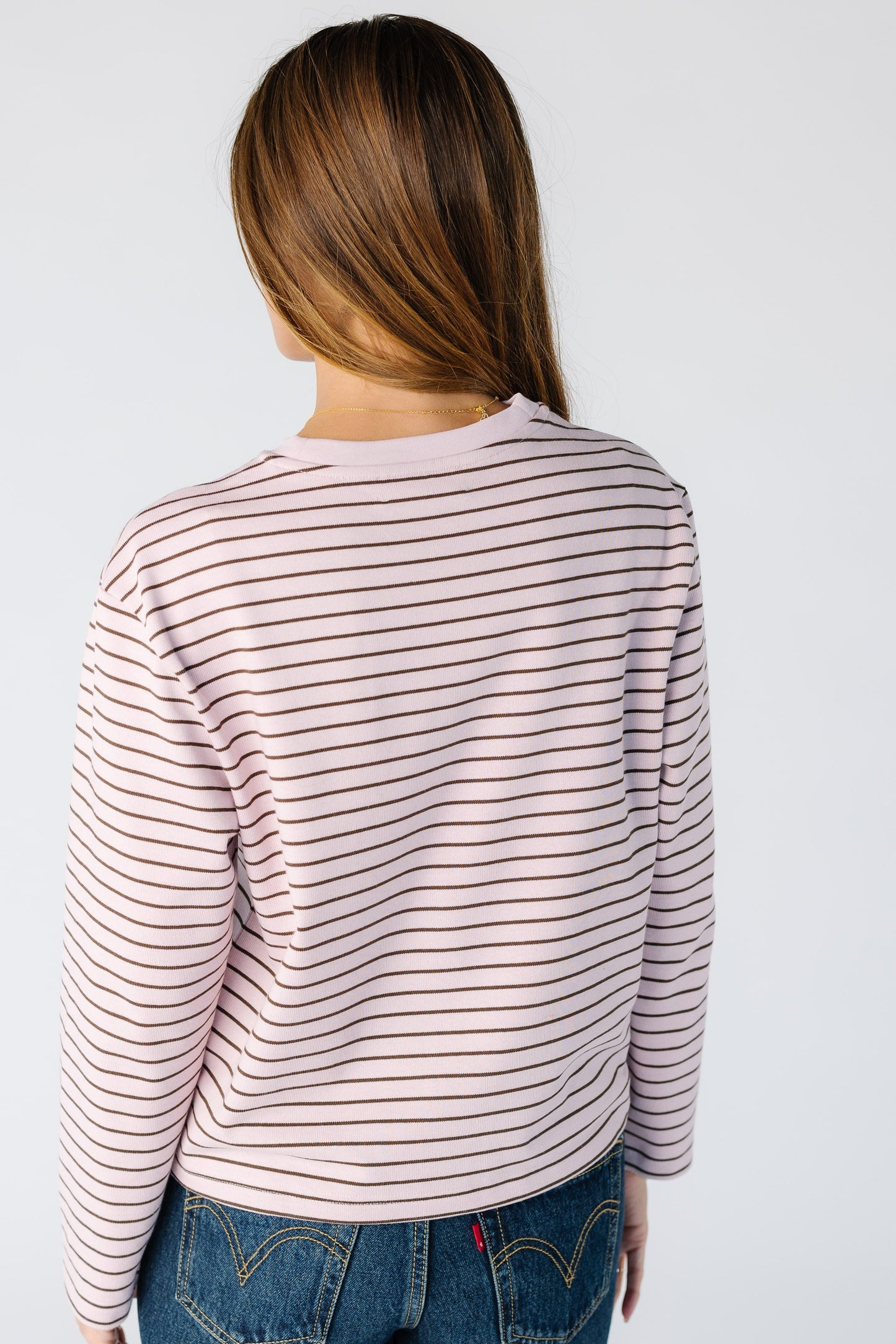 Back view of a woman wearing pink long sleeve tee 