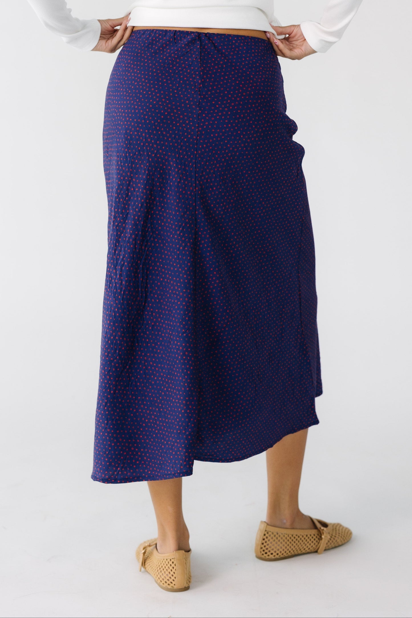 Back view of a teen girl wearing an A-line midi skirt.