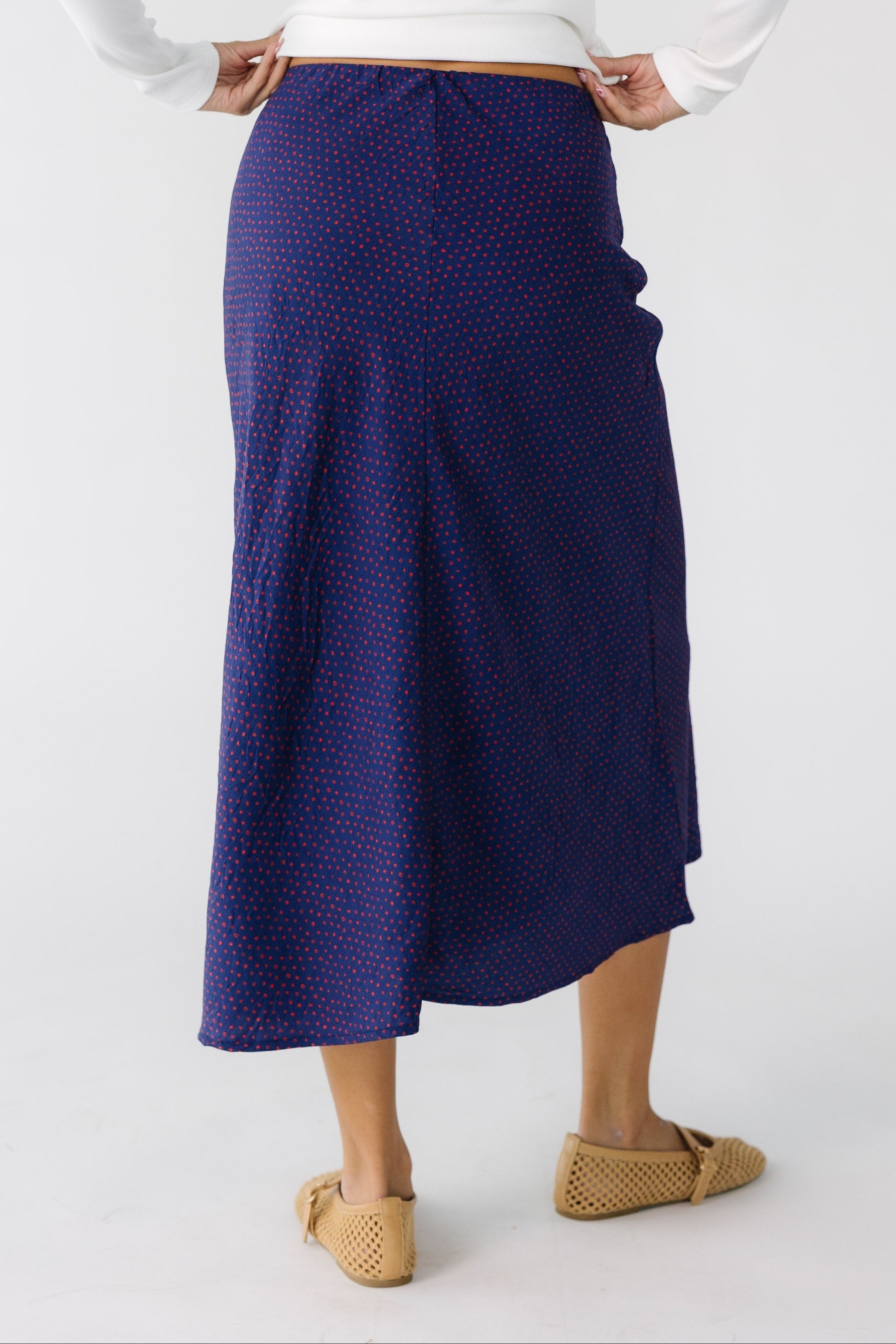 Back view of a teen girl wearing an A-line midi skirt.