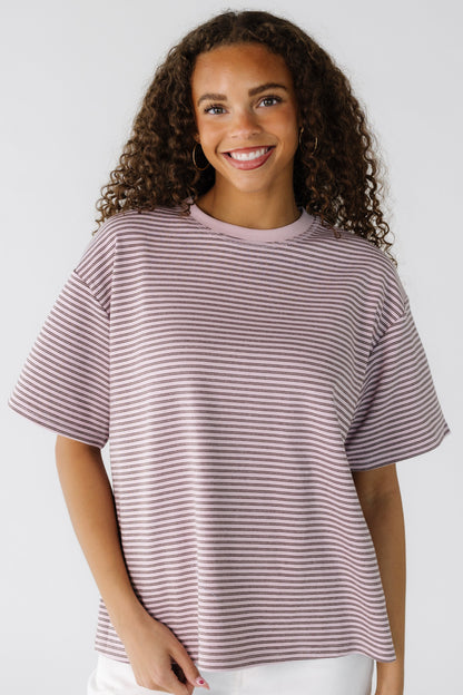 Teen girl wearing a pink and brown stripe modest tee with a crew neckline and short sleeves.