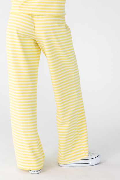 Back view of a woman wearing yellow and white loose fitting lounge pants.