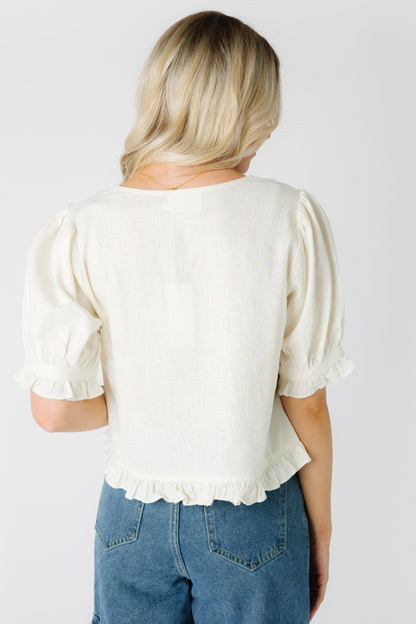 Back view of cream short sleeve top with narrow bottom ruffle