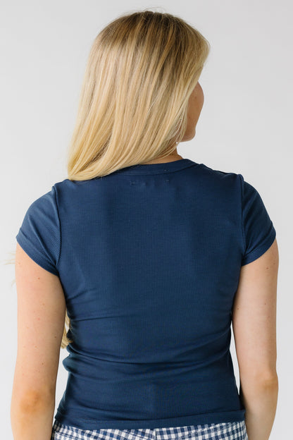 Back view of a woman wearing a navy ribbed, short sleeve tee.