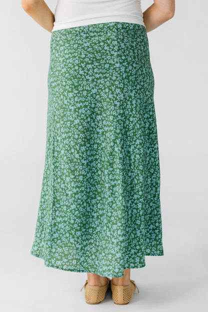 Back view of a woman wearing a green and light blue A-line midi skirt.