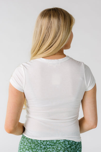Back view of a woman wearing a white, ribbed short sleeve tee.