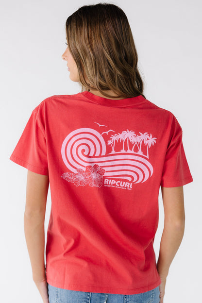 Back view of a young woman wearing a red Rip Curl graphic tee with a large back graphic.