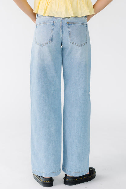 Back view of a woman wearing a pair of wide leg, loose fitting jeans.