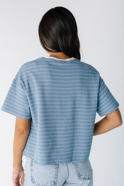 Back view of a green and blue stripe tee with short sleeves and a white crew neckline.