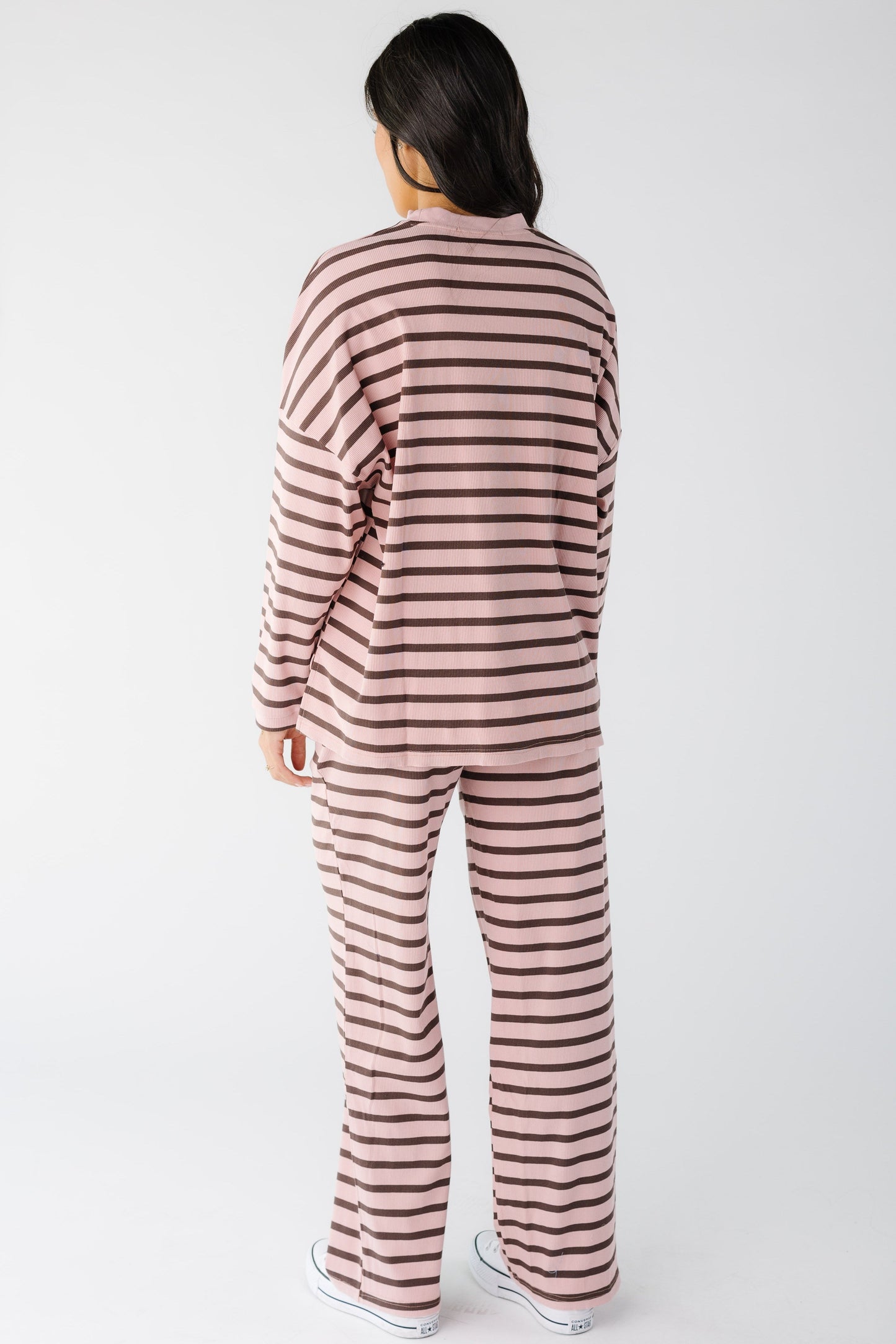 Back view of a woman wearing a pink and brown stripe lounge set.