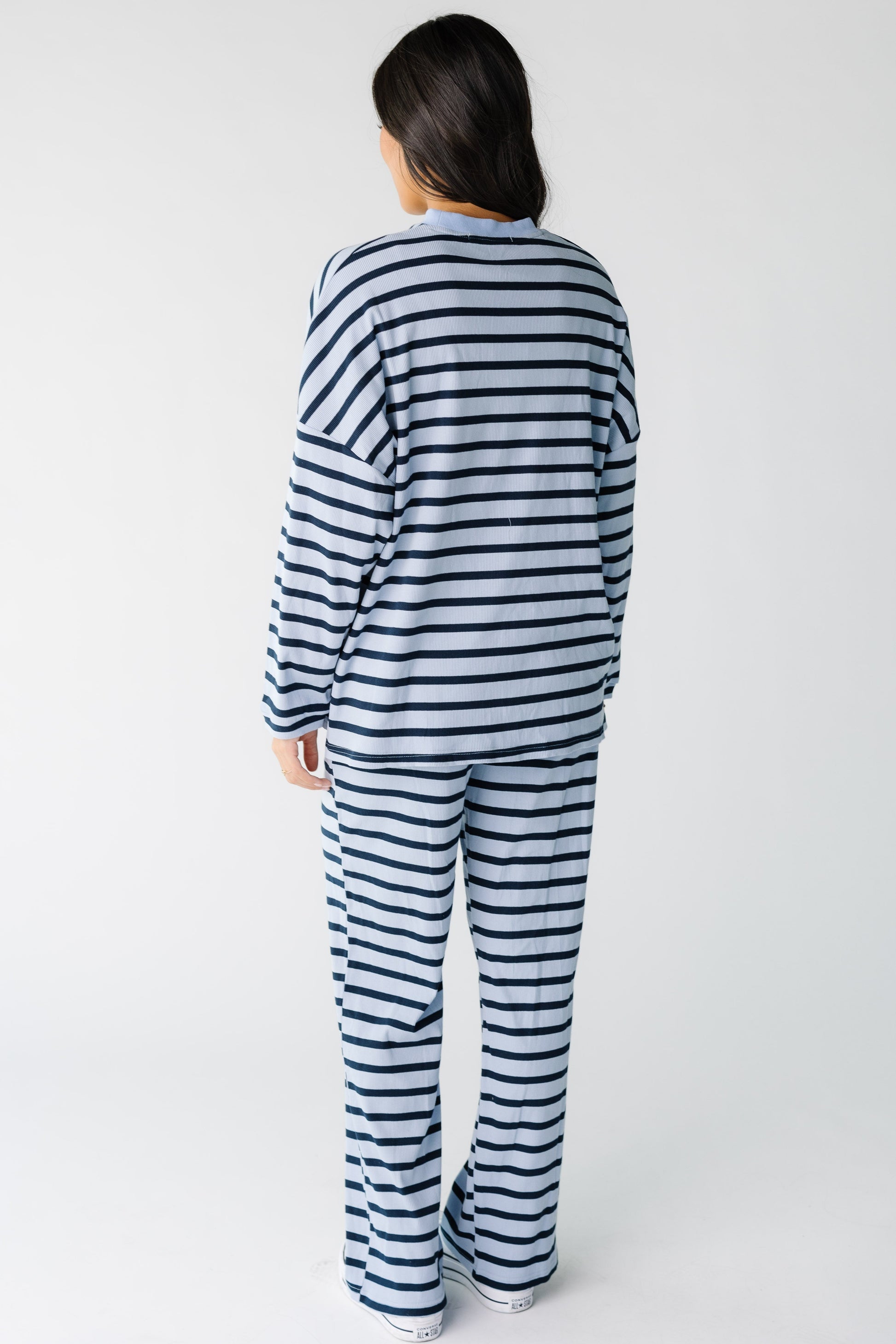 Back view of a woman wearing a light and dark blue loose fitting cotton rib lounge set.