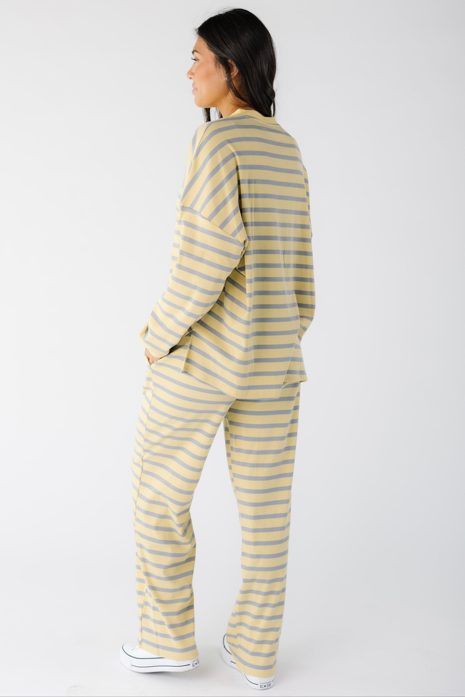 Back view of a woman wearing a yellow and blue stripe lounge set.
