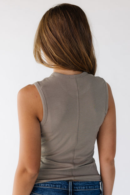 Back view of a woman wearing a tan tank top.